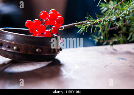 Scène d'hiver avec des branches vertes de pins, Holly, Juniper, cônes, star, fruits rouges à l'épine-vinette du semoir en bois naturel patiné, arrière-plan sur l'écorce à l'extérieur et de l'espace, lumière du jour Banque D'Images