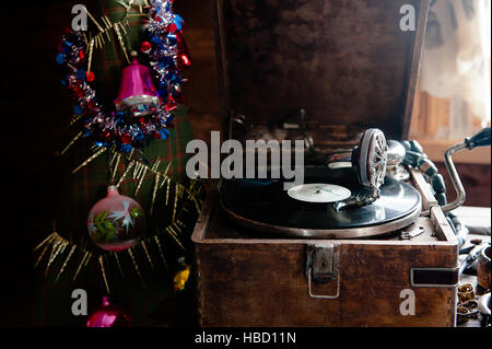 La lecture d'un gramophone record. avec du vinyle sur fond de décorations, cap, d'arbres et lumières lumineuses Banque D'Images