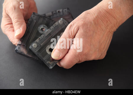 Man avec trois vieilles cassettes sur un fond sombre avec copie espace Banque D'Images
