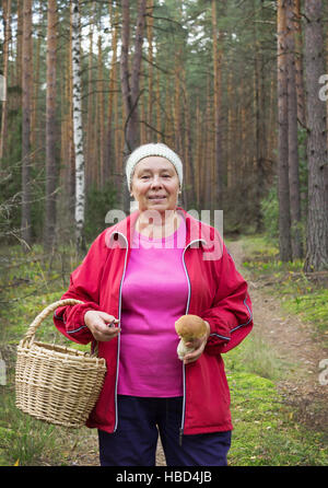 Femme de champignons trouvés dans la forêt de pins Banque D'Images