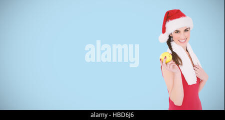 Image composite de mettre en place des fêtes brunette holding apple Banque D'Images