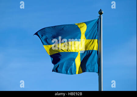 Le drapeau suédois jaune et bleu dans le vent contre un ciel d'un bleu de Flagstaff Banque D'Images