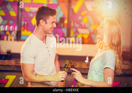 Image composite de l'heureux couple toasting with a beer bottles Banque D'Images