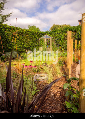 Les zones de jardin divisé à l'aide de piquets en bois pour créer des chambres en plein air dans un design moderne et contemporain Banque D'Images