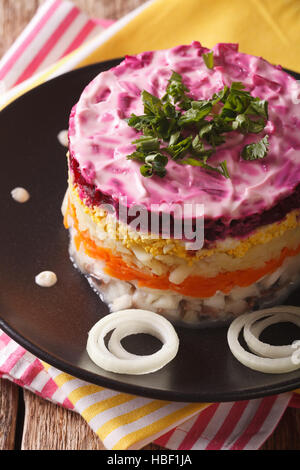 Salade de harengs en couches sous un manteau de fourrure sur une plaque verticale. Banque D'Images