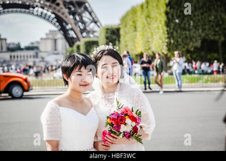 Brides ayant un moment romantique le jour de leur mariage à Paris, en face de la tour Eiffel Banque D'Images
