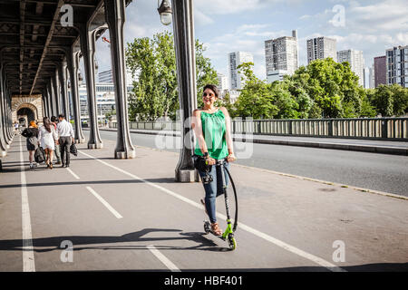 Beauté sur scooter. Les jeunes excités et belle femme riding scooter le long de à Paris, France. Banque D'Images