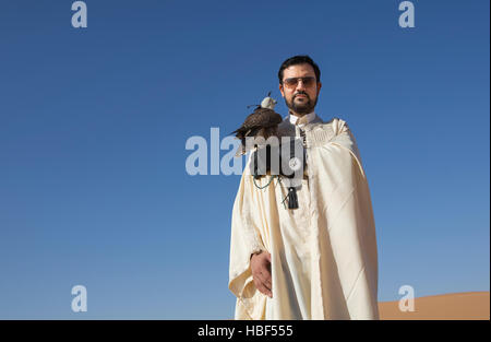 Homme tunisien avec un seaker falcon dans un désert au lever du soleil Banque D'Images