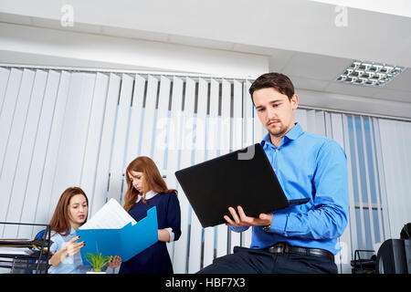 Jeune homme avec une barbe working at laptop assis sur le Banque D'Images