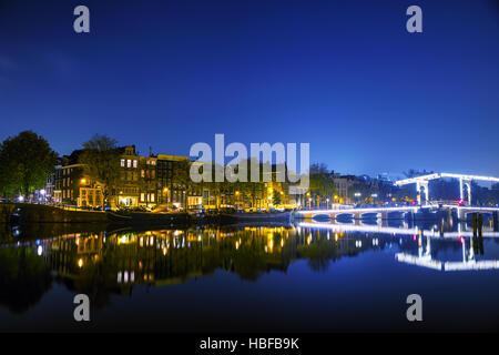 Vue sur la ville d'Amsterdam avec ses canaux et ses ponts la nuit Banque D'Images
