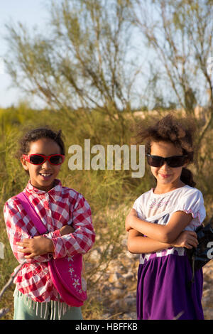 Deux jeunes soeurs marocaines qui posent avec des lunettes de soleil et nature background Banque D'Images