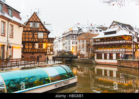 Bateau d'excursion avec les touristes le long de la rivière Ill Petite France à Noël , Strasbourg, Alsace, Bas Rhin France Banque D'Images