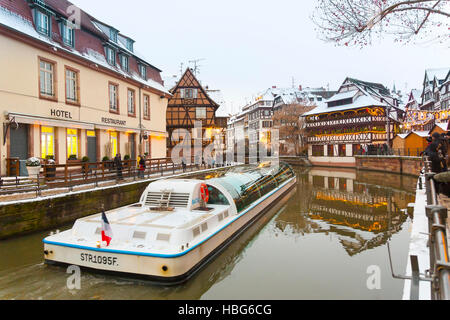 Bateau d'excursion avec les touristes le long de la rivière Ill Petite France à Noël , Strasbourg, Alsace, Bas Rhin France Banque D'Images