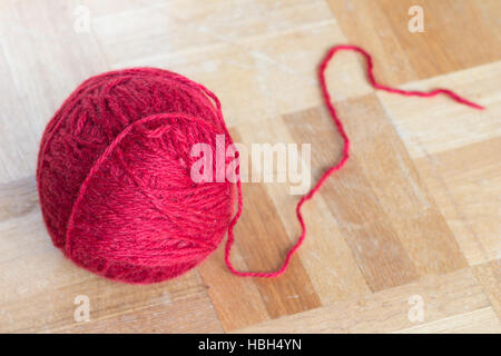 Fil rouge balle sur le plancher en bois Banque D'Images