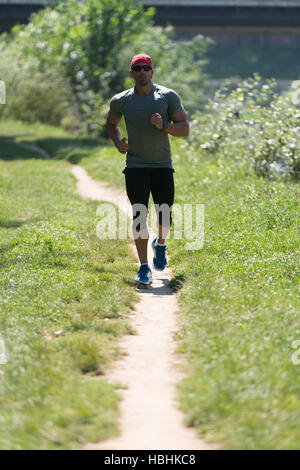 Jeune homme d'exécution en bois de forêt - formation et l'exercice d'Endurance Trail Marathon Run - Remise en Forme de vie sain Concept Banque D'Images