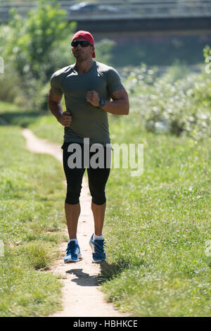 Jeune homme d'exécution en bois de forêt - formation et l'exercice d'Endurance Trail Marathon Run - Remise en Forme de vie sain Concept Banque D'Images