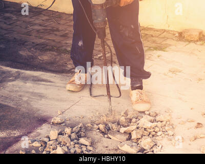 Close up homme travailleur plancher de béton de ciment forage mason avec la machine Banque D'Images