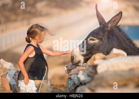 Petite fille avec un âne sur l'île de Mykonos Banque D'Images