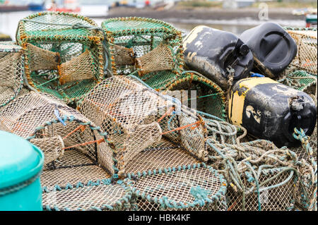 Pile de crèches ou de pots de crabe et/ou de homard sur le quai dans le port en Irlande. Banque D'Images