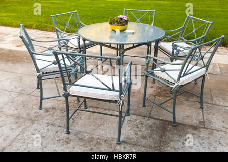 Restaurant en extérieur intérieur fond métal, chaises autour de la table ronde avec table en verre Banque D'Images