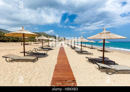 Des parasols et des chaises longues à la mer grecque Banque D'Images