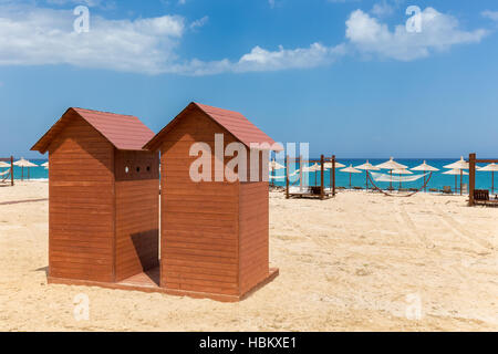 Deux cabines de plage en bois sur la côte de sable grec Banque D'Images