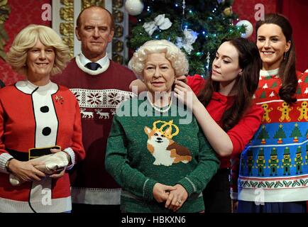 Un membre du personnel fait les ajustements nécessaires à la figure de cire de la famille royale portant leurs cavaliers de Noël à Madame Tussauds, à Londres, à faire prendre conscience de l'organisation Save the Children. Banque D'Images