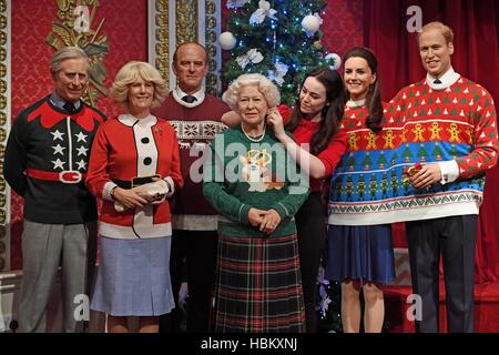 Un membre du personnel fait les ajustements nécessaires à la figure de cire de la famille royale portant leurs cavaliers de Noël à Madame Tussauds, à Londres, à faire prendre conscience de l'organisation Save the Children. Banque D'Images