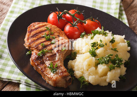 Steak de porc grillé avec purée de pommes de terre et garnir les tomates sur une plaque horizontale. Banque D'Images
