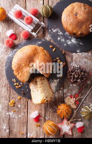 Panettone pain aux fruits et décoration de Noël close-up sur la table. vertical Vue de dessus Banque D'Images