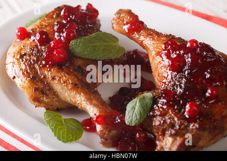 Cuisse de canard rôti avec la sauce aux canneberges et menthe libre sur une plaque horizontale. Banque D'Images