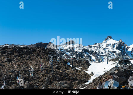 Skieurs sur téléski sur la roche volcanique à Alpe Ski Area, New Zealand Banque D'Images