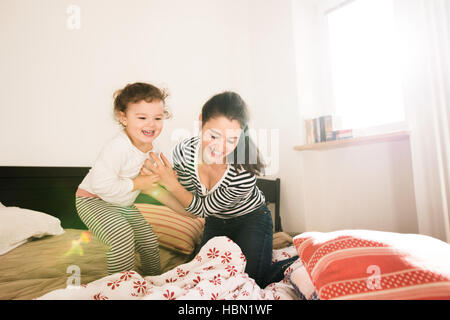 Mère s'amusant avec sa fille dans sa chambre à coucher Banque D'Images