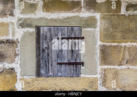 Mur de pierre avec une trappe en bois Banque D'Images