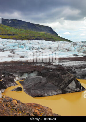 La glace bleu couvert de cendres volcaniques noir Banque D'Images