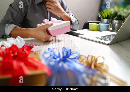 Donner de cadeau main créatrice le choix et la main avec don. Livraison de cadeaux, surprise, ordinateur portable et téléphone intelligent sur mable 24,effet film filtre Banque D'Images