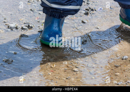 Les enfants les jambes dans des bottes en caoutchouc bleu Banque D'Images