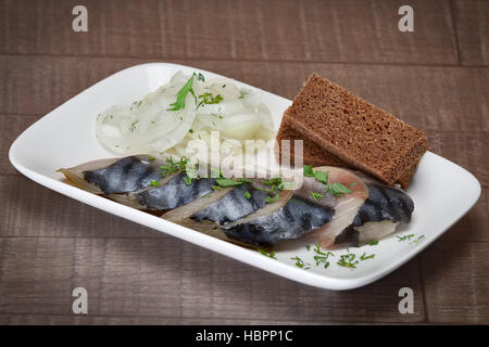 Collation froide - morceaux de hareng mariné avec du pain et de l'oignon. Banque D'Images