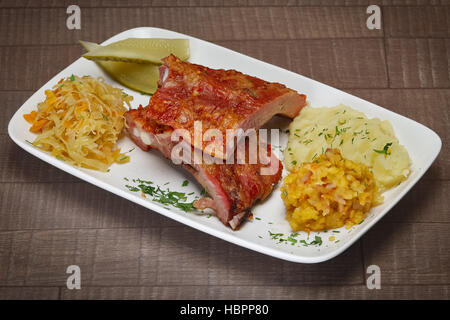 Côte de boeuf grillée moyen servi avec purée de pommes de terre, le concombre et le chou Banque D'Images