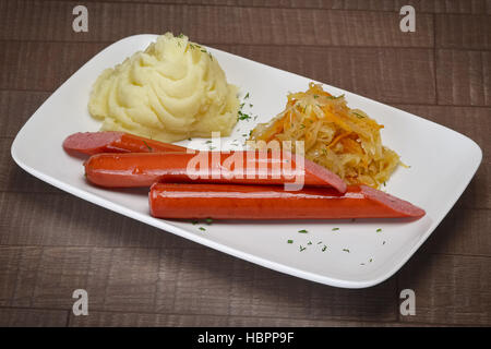 Frankfurter sausage poêlée de choux et purée de pommes de terre sur la table en bois Banque D'Images