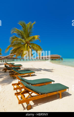 Des chaises longues sur la plage aux Maldives Banque D'Images