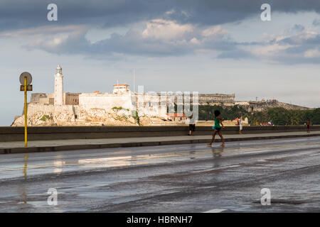 La vive lumière du soleil contraste contre un ciel orageux sur le Malecon ocean highway à La Havane la fin d'un après-midi dans la capitale cubaine. Banque D'Images