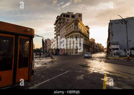 Un bus orange traverse le Prado à La Havane (route qui sépare la vieille ville et Centro Havana) juste avant le crépuscule dans la capitale cubaine. Banque D'Images