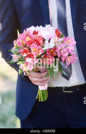 Groom détient les mariées bouquet à jour de mariage Banque D'Images