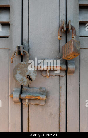 Rusty old cadenas et boulons de verrouillage sur les portes métalliques Banque D'Images