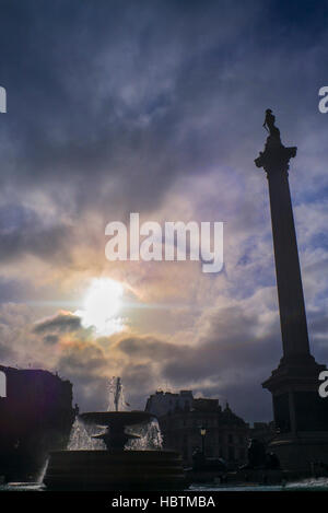 Silhouette de la Colonne Nelson & nuages d'or fontaine à Trafalgar Square, Londres, UK Banque D'Images