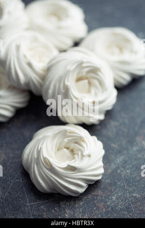 La meringue blancs doux sur noir table de cuisine. Banque D'Images