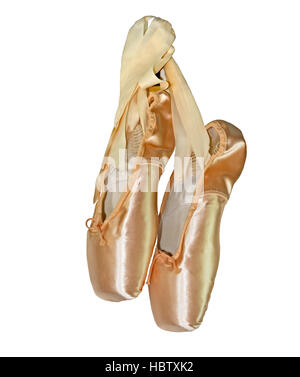 Chaussons de ballet rose accrochée à leurs liens ruban isolé sur un fond blanc. Banque D'Images