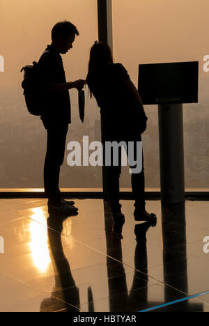 Silhouettes observant le couple vue aérienne pendant le coucher du soleil à Saigon Banque D'Images