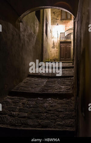 La ville médiéval de Barga, possède de nombreuses rues étroites et les ruelles qui prennent vie grâce à la lumière artificielle la nuit. en Toscane, Italie. Banque D'Images